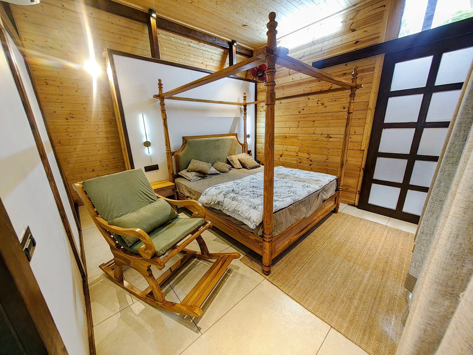 Bedroom reading nook with a wooden rocking chair beside the bed