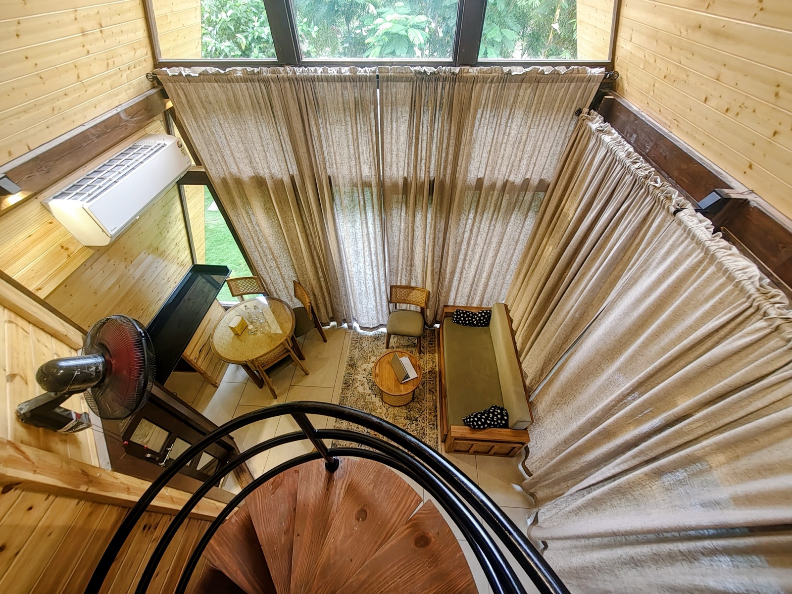 Cosy timber-lined cabin lounge with soft curtains and seating