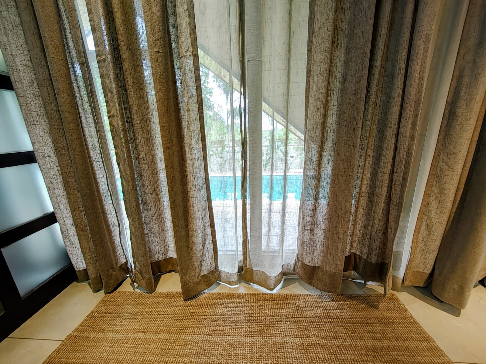 The private pool glimpsed through soft linen drapes